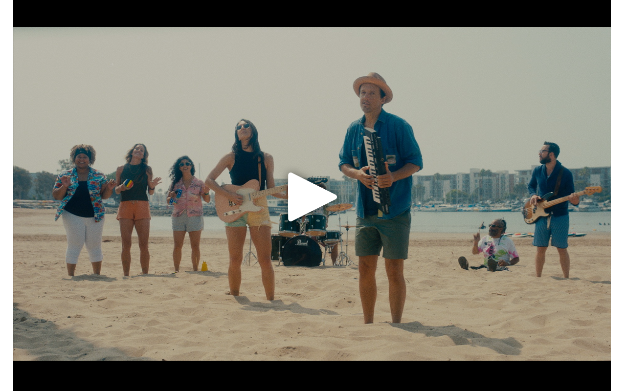 Jason Mraz and band on the beach with feet stuck in the sand